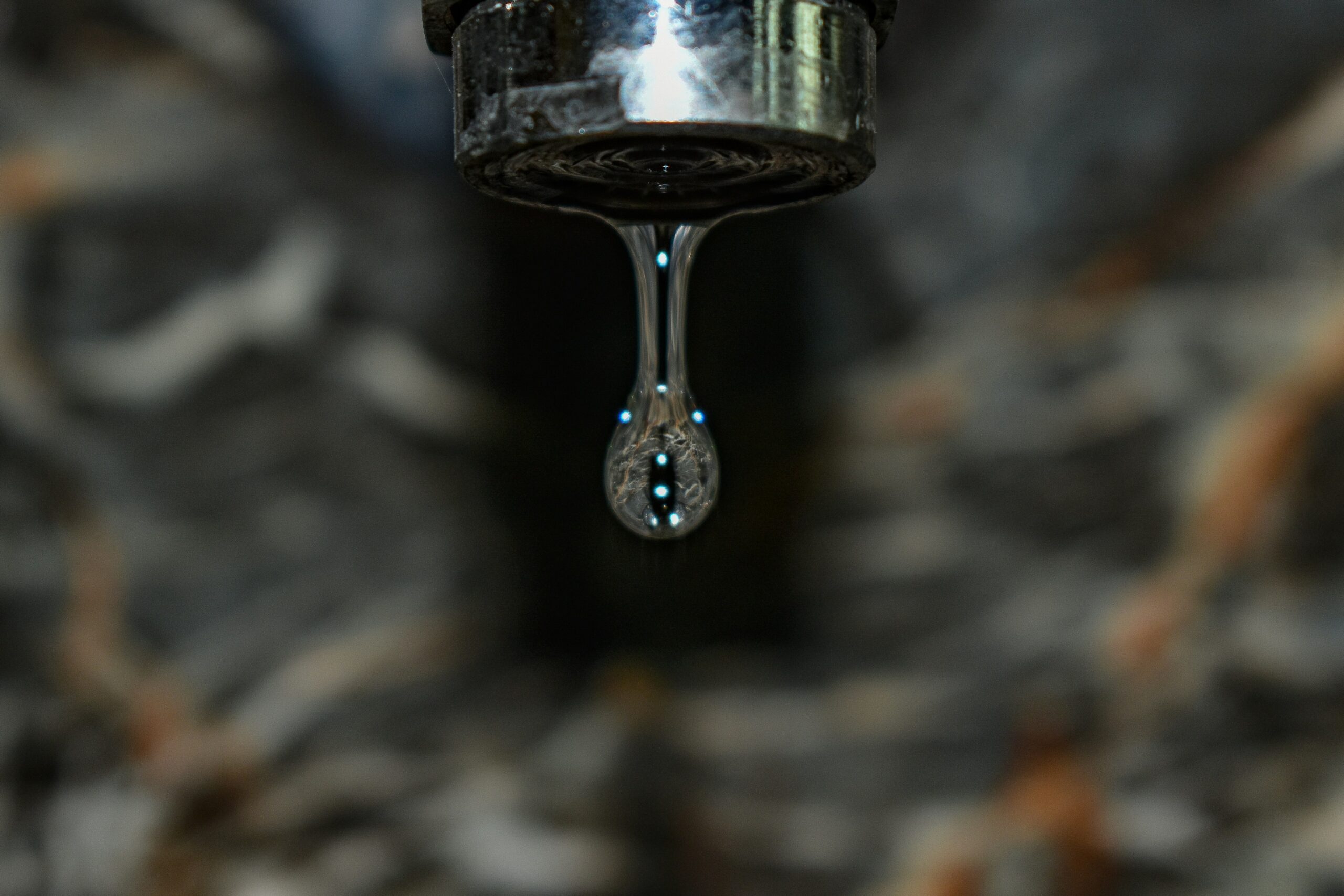 Close-up of a dripping faucet requiring leak detection service from Plumbing Doctor.